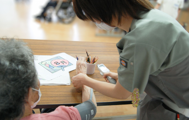 博愛記念病院で患者さんの血圧を測る看護師